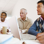 Image of three people standing reading a notebook