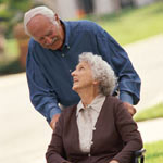 Image of a man pushing a woman in a wheelchair