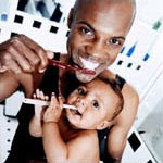 Image of father and child brushing teeth