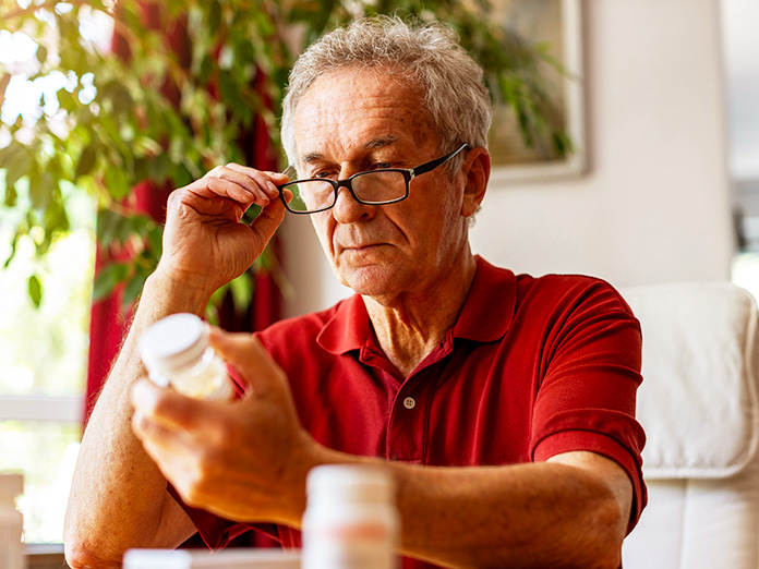 Image of a pharmacist helping an older lady pick out a prescription in an aisle of a CVS
