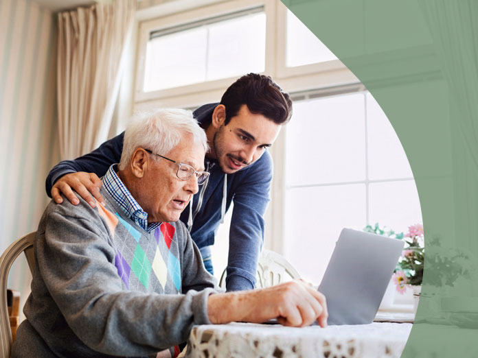 a man helping his father on the computer look up the difference between medicare and Medicaid
