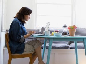 woman on laptop at kitchen table