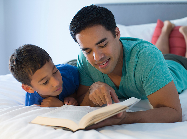 Father and son reading on bed