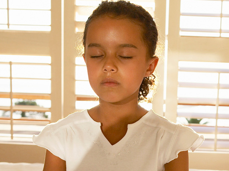 girl meditating on bed