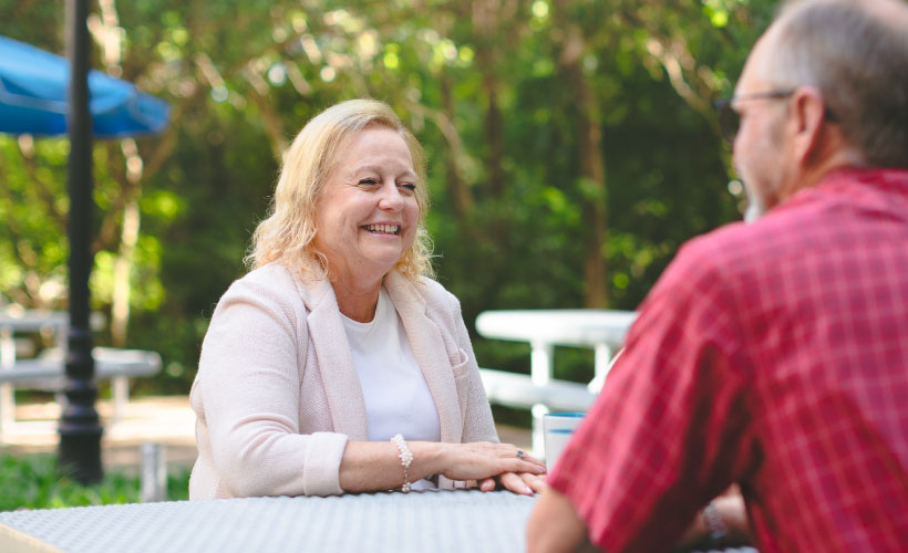 an Aetna Medicare customer service representative discussing medicare questions with a fellow older gentleman in person