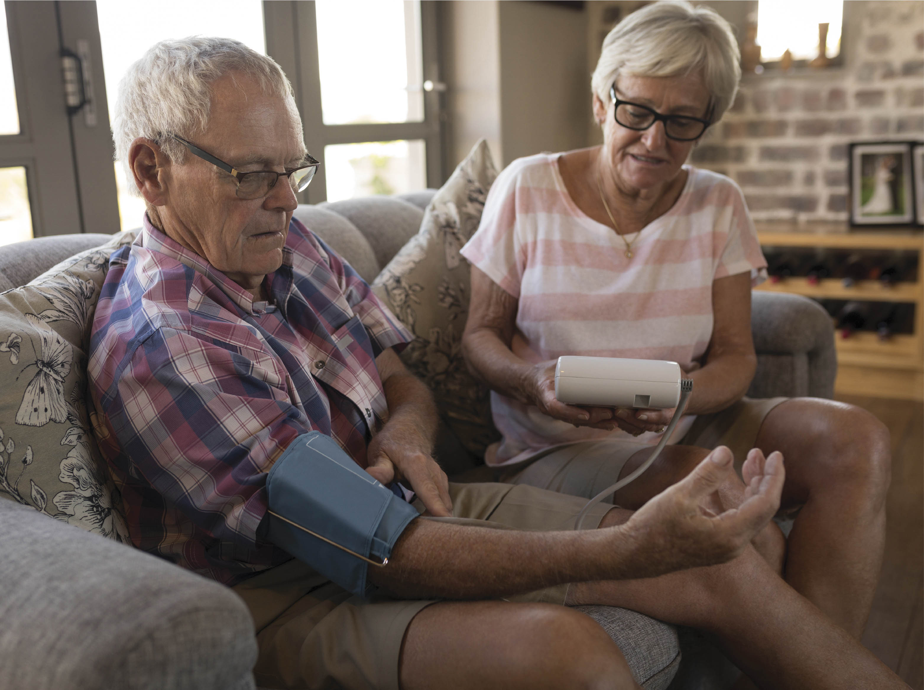 Woman taking man's blood pressure