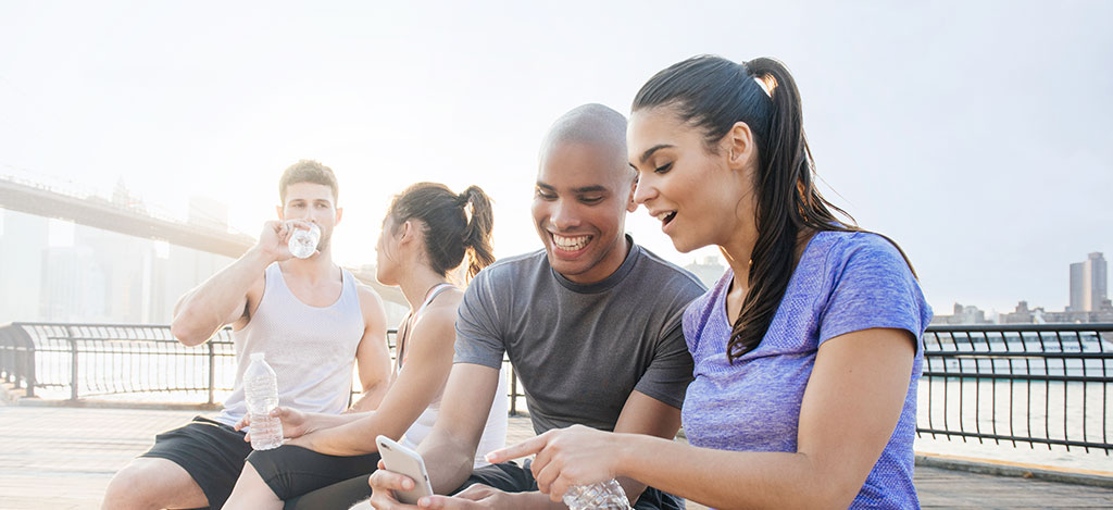 pareja que busca en un teléfono por el río en la ciudad
